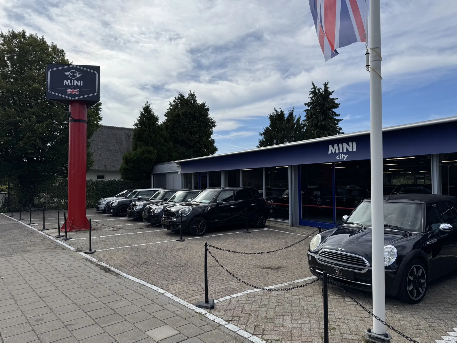 Buitenaanzicht van de MINI City showroom met de voorraad achter de kettingen op het buitenterrein
