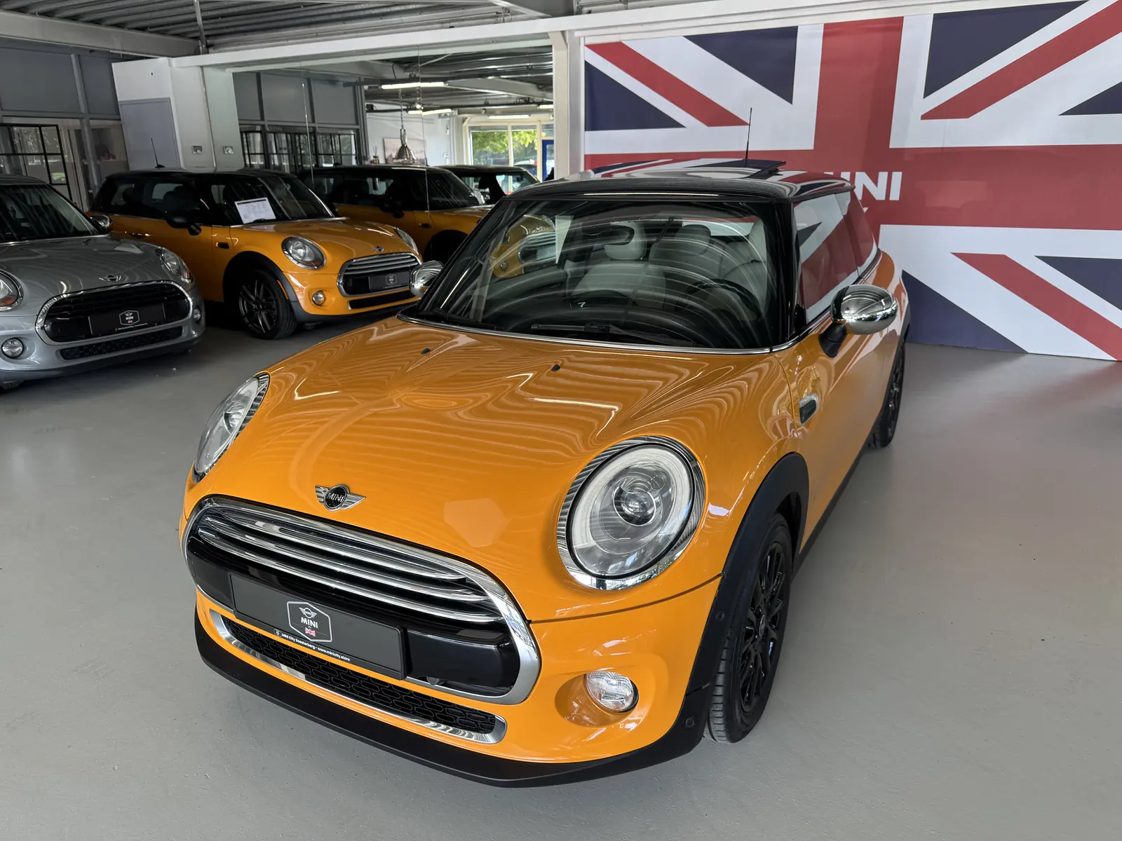 MINI Cooper 2014 in oranje, driekwart voor, ander standpunt