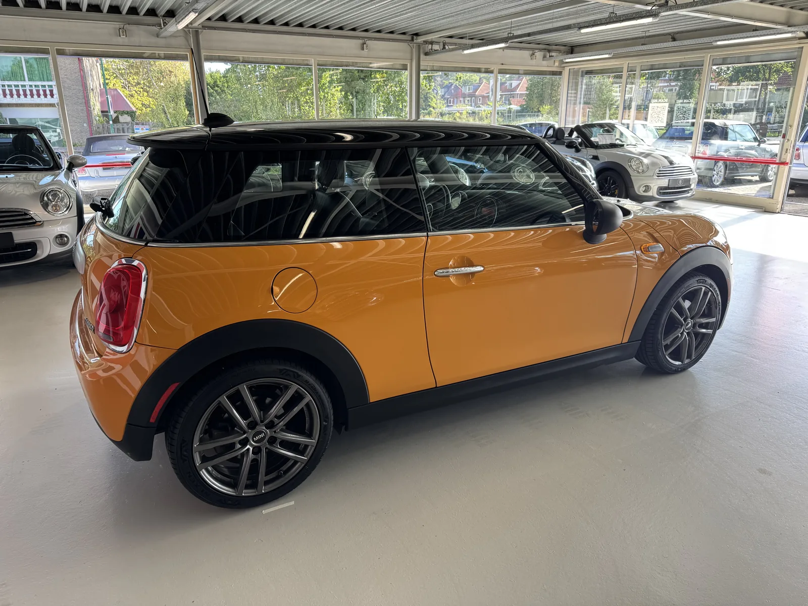 MINI Cooper 2015 in oranje, zijaanzicht rechts
