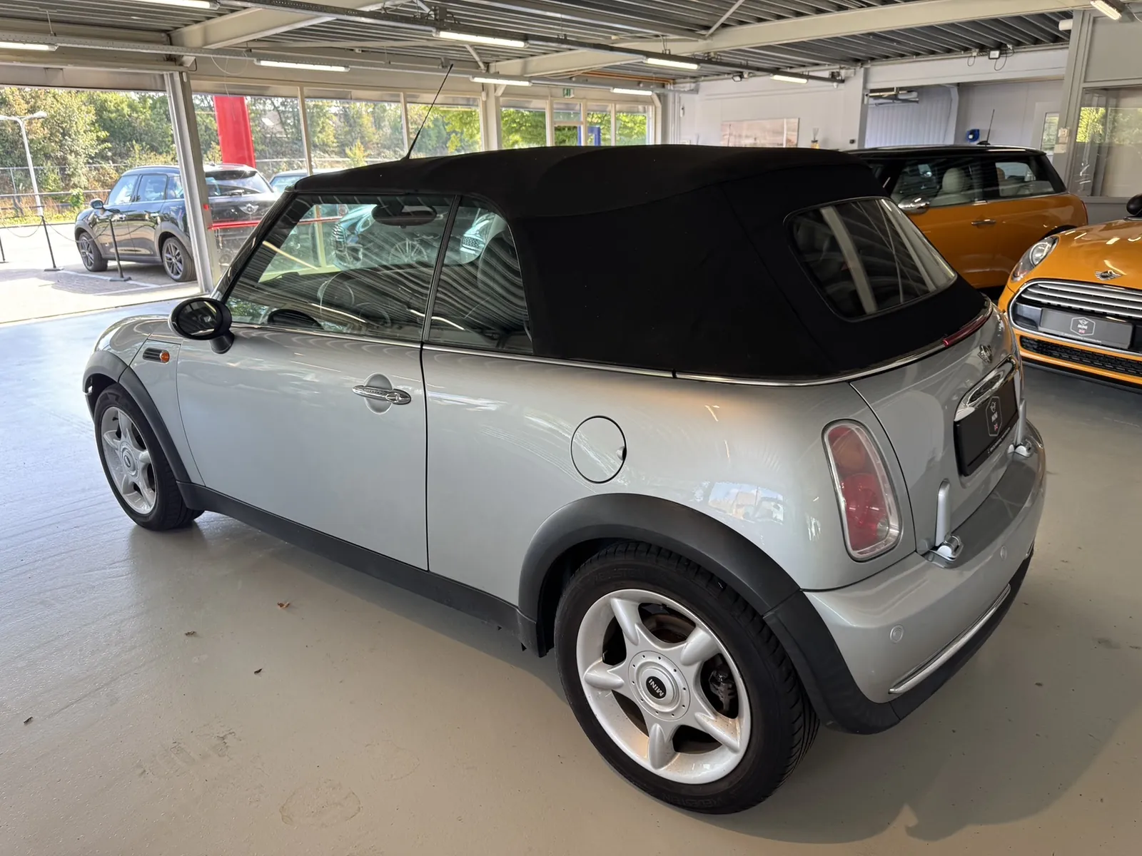 MINI Cooper Cabrio 2004 in zilver, zijaanzicht driekwart achter, kap dicht