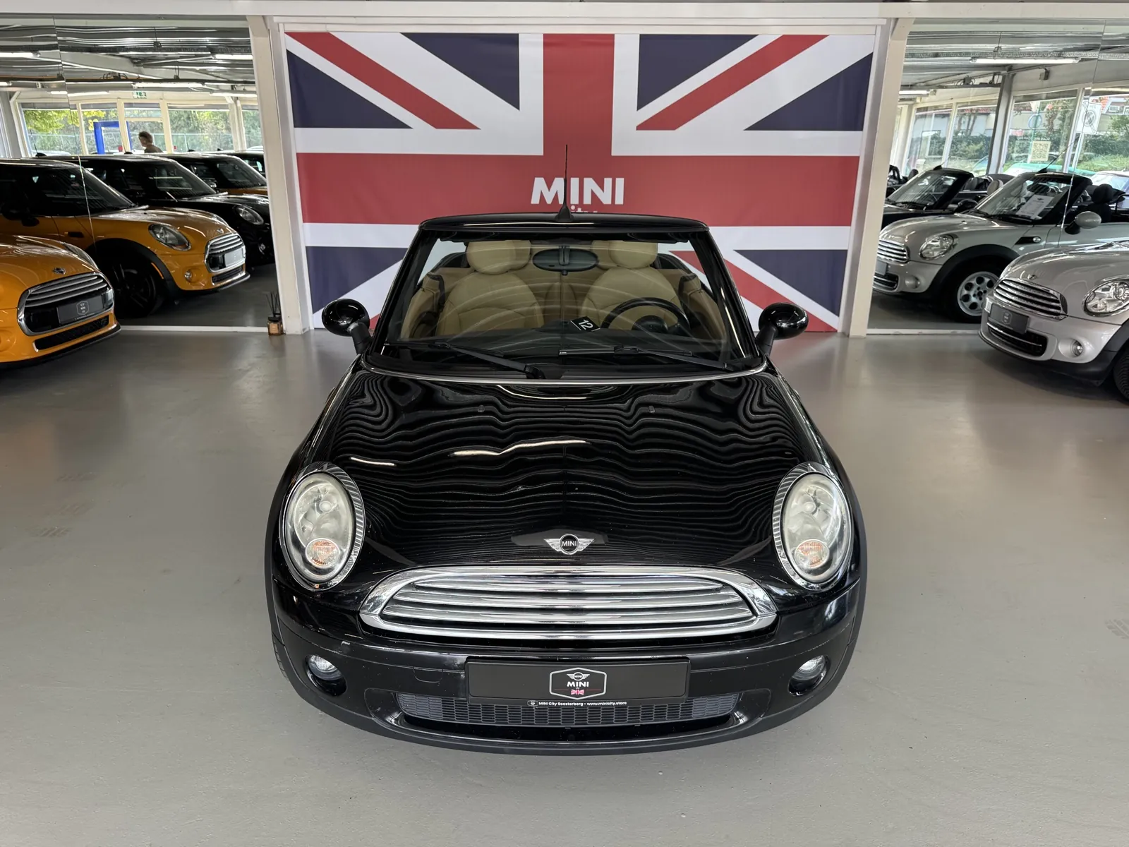 MINI Cooper Cabrio 2009 in zwart, vooraanzicht met open kap